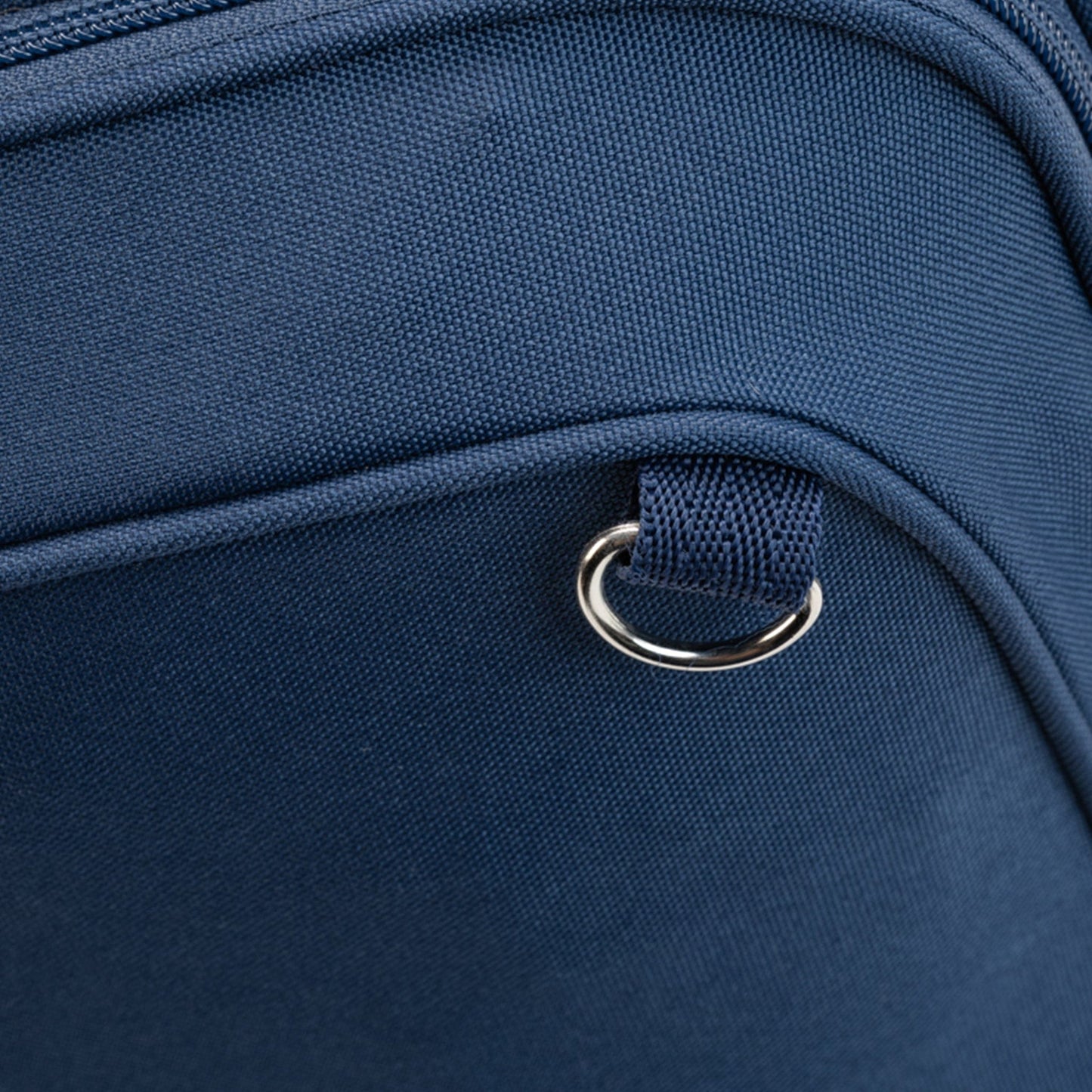 Close-up of a metal attachment on the navy Totem Bags school bag front pocket seam.