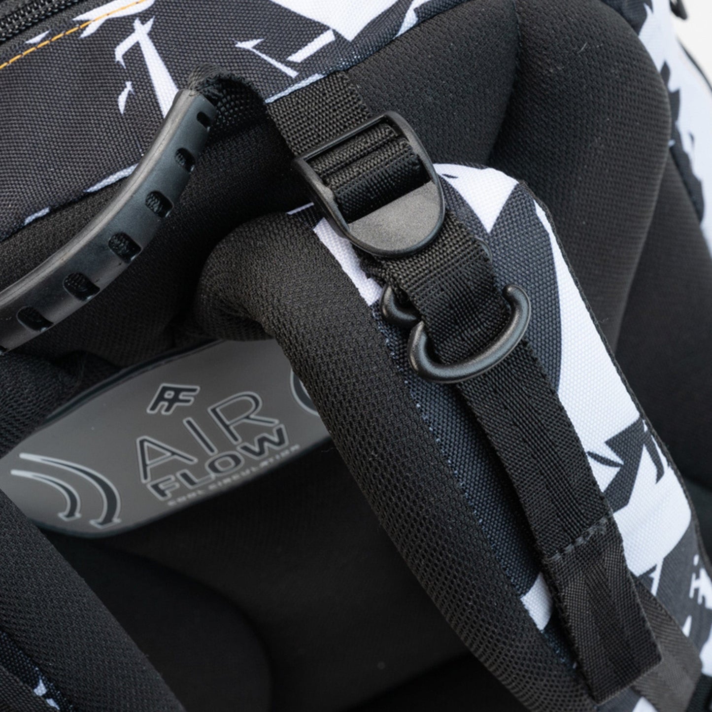 A close-up of the strap adjuster, D-ring, and vented handle on an ergonomic school bag’s shoulder area.