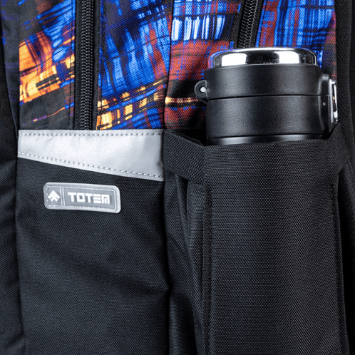 A black side pocket with a stainless flask, grey reflector and blue, orange print, part of a Savvy School bag.