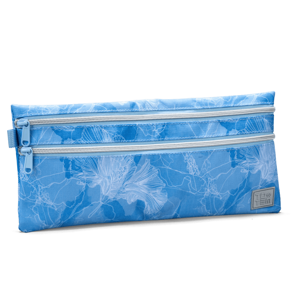 Angled view of a blue Totem pencil case with double zippers and a floral outline design, shown against a black background.
