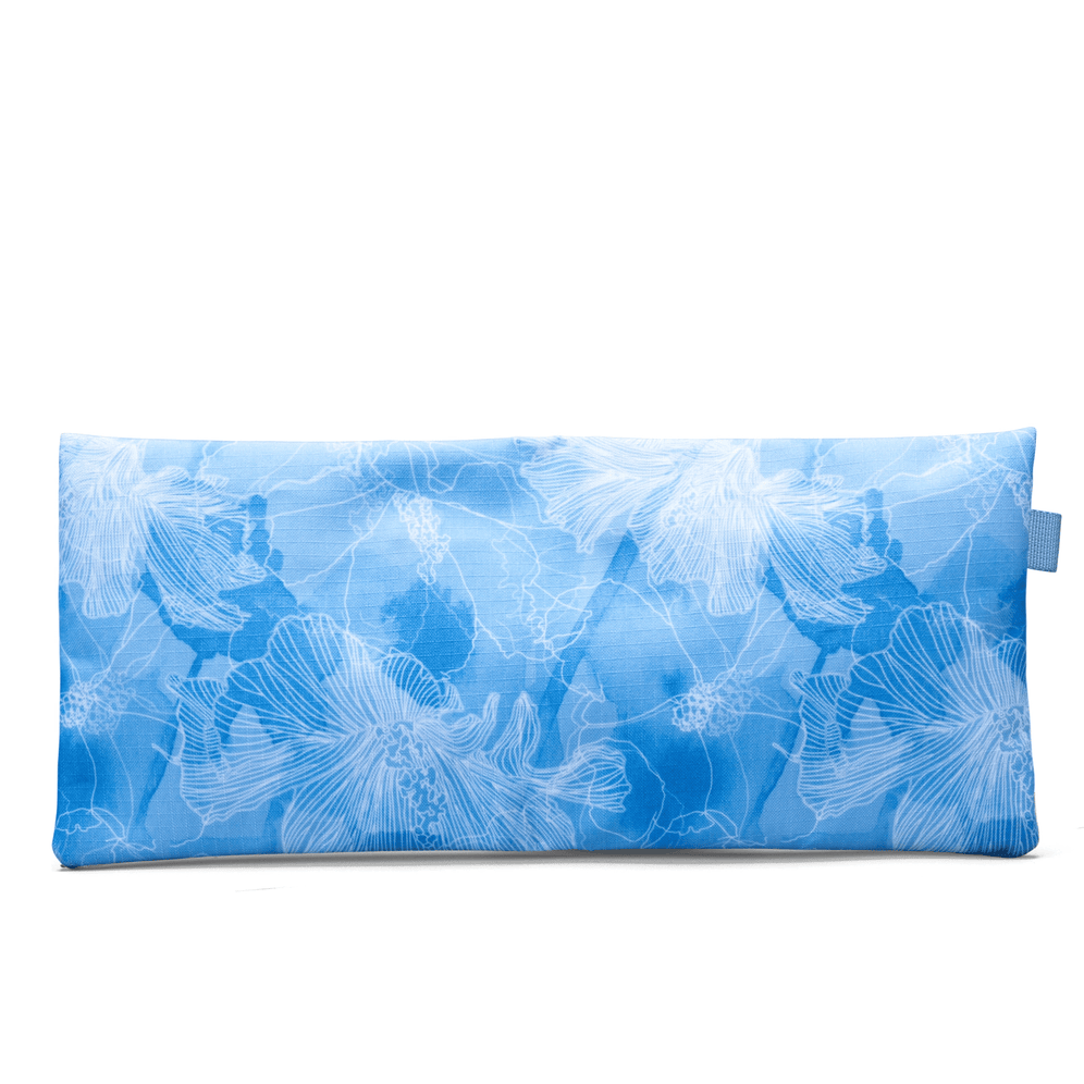The rear view of a Totem blue pencil case with a white floral print across the fabric and a small side tab.