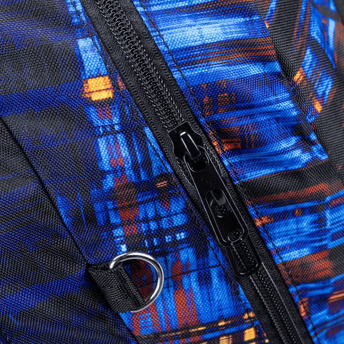 A close-up of a Totem School bag zip and D-ring on textured fabric in electric blue with orange accents.