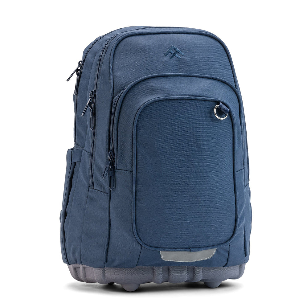 The front three-quarter view of a navy Totem ergonomic school backpack with multi-zip compartments and a D-ring.